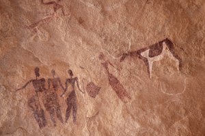 Rotstekeningen, Prehistorie: Rotsschildering van een groep personages en een tweekleurige koe met grote hoorns in een versierd onderkomen, in het Uweinat-massief, Egypte. (Periode van 8000 tot 3000 jaar v.Chr.). Fotografie door Unbekannt