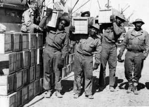 Tweede Wereldoorlog (1939-1945): Midden-Oosten april 1943: In een haven lossen leden van een havenbataljon van het Amerikaanse leger, Afro-Amerikanen, militair materieel. door Unbekannt