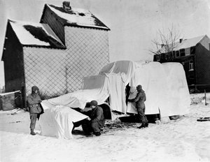 Tweede Wereldoorlog (1939-1945): In de buurt van Bastogne (België) eind december 1944: Deze Amerikaanse soldaten gebruiken witte lakens om een vrachtwagen te camoufleren voor de vijand