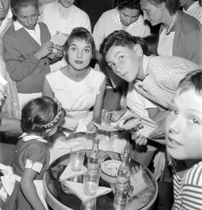 De actrice en mode model Elsa Martinelli op het XVIII Internationale Filmfestival in Venetië Lido (ze signeert handtekeningen met jonge fans. Op de tafel, een fles Schweppes) - 1957