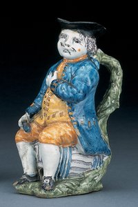 Toby-kruik met bleek mangaan gezicht en handen, houdend een lege bolvormige buffkleurige kruik in gewassen blauwe jas en broek, en groene vest, ca. 1800 door Unbekannt