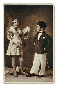 Twee kinderen verkleed als volwassenen in de mode van de jaren 1920, het meisje draagt een outfit voor de Charleston, en hij in pak, bolhoed en sigaret. Fotografie
