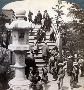 Gelovigen steken de halfronde brug over naar de Kameido-tempel, kijkend naar het noorden, Tokio, Japan door Underwood and Underwood