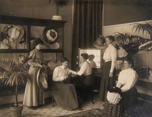 Vijf dames in een hoedenwinkel