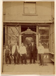 [Vier mannen en een jongen staan voor een openbaar badhuis].