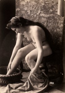 Portret van een naakte vrouw die haar voeten wast door Unknown photographer