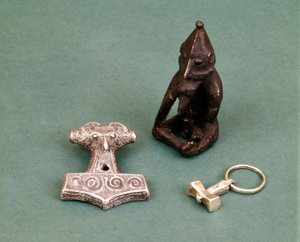 Amuletten van Vikinggoden: op de voorgrond twee kleine zilveren hamers die de god Thor symboliseren. Het beeldje stelt Freyr voor, god van de vruchtbaarheid. Historisch Museum van Stockholm, Zweden.