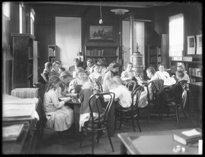Kinderen lezen in de leeszaal van een niet-geïdentificeerde vestiging van de Queens Borough Public Library, ca. 1910 door William Davis Hassler