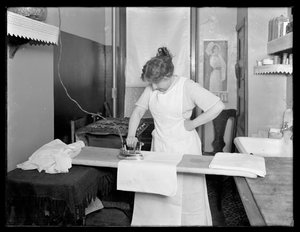 Onbekende vrouw die het gebruik van een elektrisch strijkijzer demonstreert ca. 1913-14 door William Davis Hassler