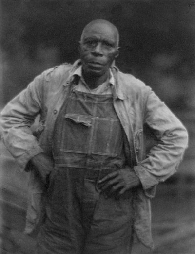Man in overall door American Photographer