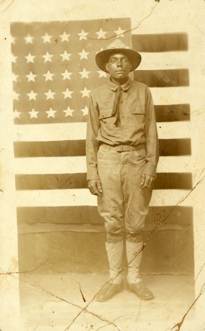 Eerste Wereldoorlog soldaat met Amerikaanse vlag op de achtergrond, 1914-18 door American Photographer