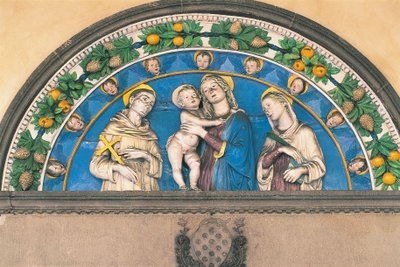 Glazen terracotta lunet met Madonna met kind tussen heiligen door Andrea Della Robbia
