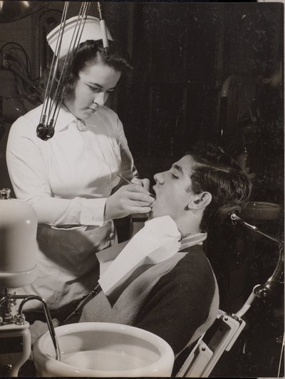 [Mondhygiënist inspecteert de mond van een patiënt]. door Arnold Eagle