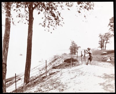 Zicht op een jongen met een verrekijker die naar de Hudson River kijkt vanuit Riverside Park, New York door Byron Company