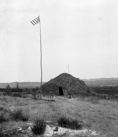 Rondhuis, Am-mah’sha-nah, met vlag en een onduidelijke annotatie Rondhuis bij Stonehenge door C. Hart Merriam