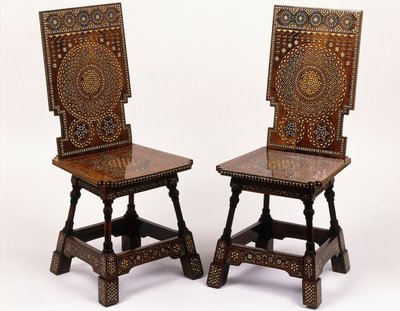 Een paar mahoniehouten stoelen met tinnen en ivoren ingelegde bloemendecoratie door Carlo Bugatti