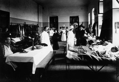 Versierde salon in een ziekenhuis met oorlogswonden, artsen, Rode Kruis-verpleegsters en bezoekers door Carlo Wulz