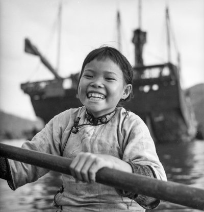 Een portret van een jong meisje in een sampan in de haven van Aberdeen, Hong Kong door David Watkin Waters