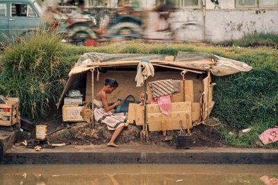 Kartonhut langs een rioolkanaal, dient als huis. Jakarta, Indonesië door Dean Conger