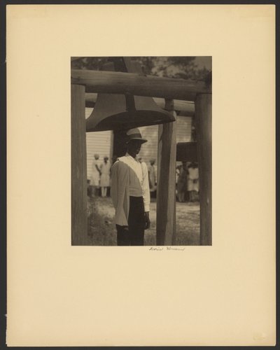 [Zwarte man staat onder een bel]. door Doris Ulmann