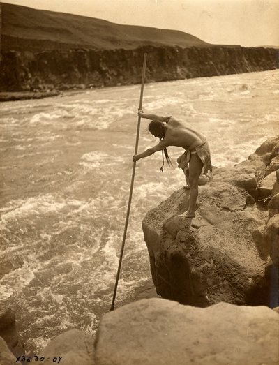 Tlakluit Indiaan, staand op rots, vist met schepnet, ca. 1910 (z/w foto) door Edward Sheriff Curtis