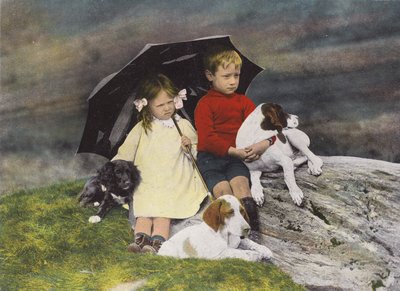 Jongen en meisje met drie honden onder een paraplu door English Photographer