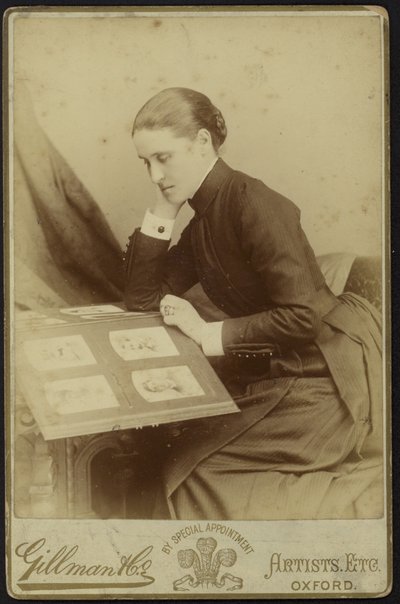 Vrouw die een fotoalbum inspecteert door English Photographer