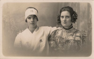 Twee jonge vrouwen, met armen om elkaars schouders door English Photographer