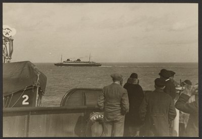 [Groep mensen op het dek van een schip die kijken naar een ander schip dat in de verte voorbij vaart]. door Erich Salomon