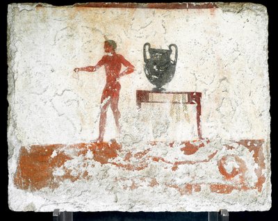 Etruskische kunst: een jonge naakte ephebe bij een tafel waar een vaas op staat. Fresco van het graf van de 