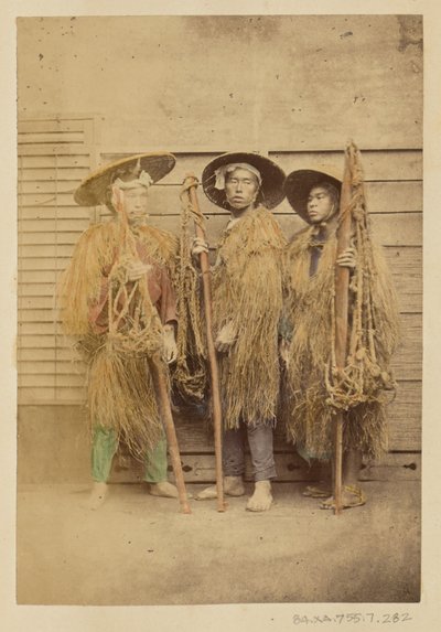 [Drie Japanse mannen in grasgewaden en breedgerande hoeden]. door Felice Beato
