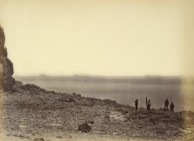 [Zicht op kust met schepen aan horizon en vijf figuren staand op strand]. door Felice Beato