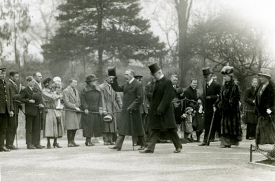 Koning George V, die zijn hoed opheft naar de menigte vooraan zijn gevolg, tijdens een bezoek aan de Londense dierentuin om officieel het aquarium te openen, april 1924 door Frederick William Bond