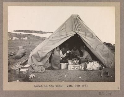 Vier expeditieleden lunchen in een tent door Herbert Ponting
