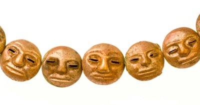 Een ketting gevonden rond de nek van de mummie met kleine gouden gezichten. door Ira Block