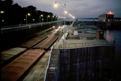 Binnenvaartschepen gaan door een sluis in de Mississippi geduwd door een sleepboot door James L Stanfield
