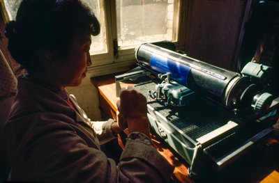 In het gemeentehuis typt een lid op een Chinese typemachine. Chun Xing Gemeente, Yunnan door James L Stanfield