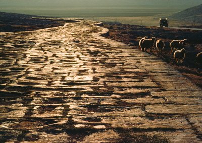 Moderne macadamweg parallel aan oude kalkstenen Romeinse weg. Nabij Aleppo, Syrië door James L Stanfield