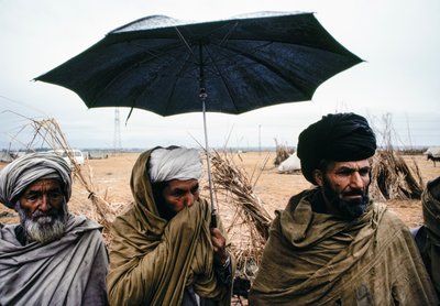 Pakistaanse mannen met een paraplu en traditionele kleding door James L Stanfield