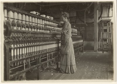 In een ouderwetse textielfabriek (spinner). door Lewis W. Hine