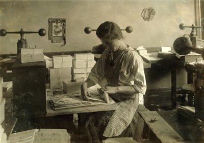 Een 15-jarig meisje snijdt matrijzen in de embossingwinkel van Harry C. Taylor, 61 Court Street in Boston, Massachusetts. door Lewis Wickes Hine