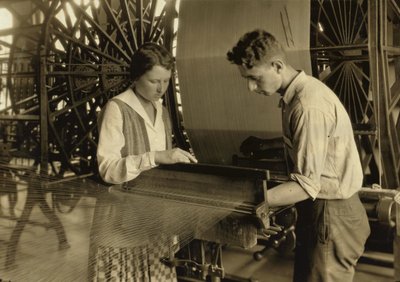 Een jongen en een meisje werken aan een weefgetouw in de Cheney Silk Mills in South Manchester, Connecticut. door Lewis Wickes Hine