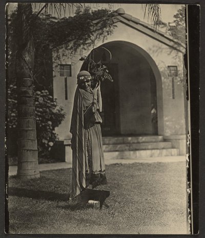 [Florence in kostuum met plant buiten het huis]. door Louis Fleckenstein