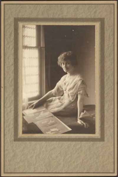 [Portret van een vrouw die naar een album kijkt]. door Louis Fleckenstein