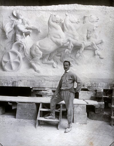 Volledig portret van de beroemde beeldhouwer Pietro Canonica. Hij poseert in zijn studio voor een marmeren hoogreliëf waar hij aan werkt door Mario Nunes Vais