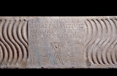 Paleochristelijke kunst: fragmentarische sarcofaagtank: Goede Herder en grafschrift van Livia Primitiva. Een herder met lammeren, een vis (christelijk symbool) en een anker. Gevonden in Rome onder de Sint-Pietersbasiliek. door Paleo Christian