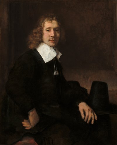 Een jonge man zittend aan een tafel mogelijk Govaert Flinck door Rembrandt van Rijn