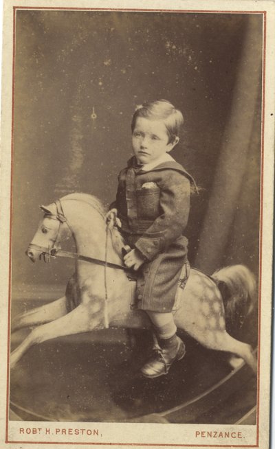 Jonge jongen zittend op een schommelpaard door Robert H. Preston