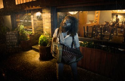 Muzikant op een regenachtige nacht door See Plus
