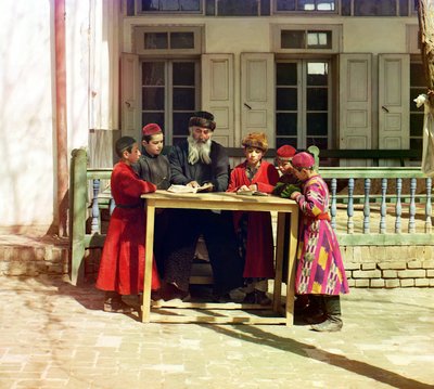 Een groep Joodse kinderen met een leraar aan een tafel voor een huis, Samarkand, Russisch Rijk, tussen 1905 en 1915 door Sergey Prokudin Gorsky
